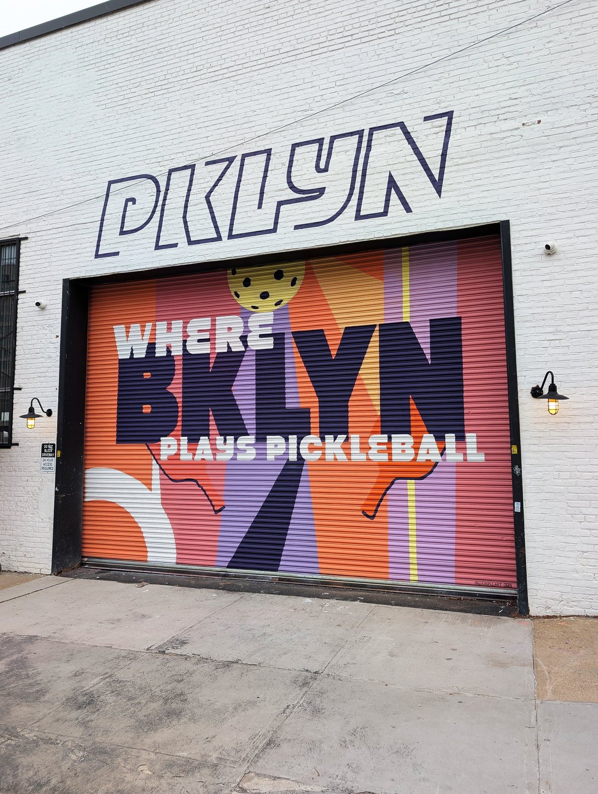 Where BKLYN Plays Pickleball — hand-painted mural on PKLYN's garage door